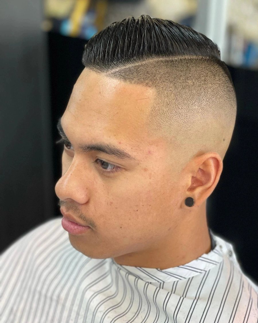 Man with a short flat top and a skin fade through the sides.