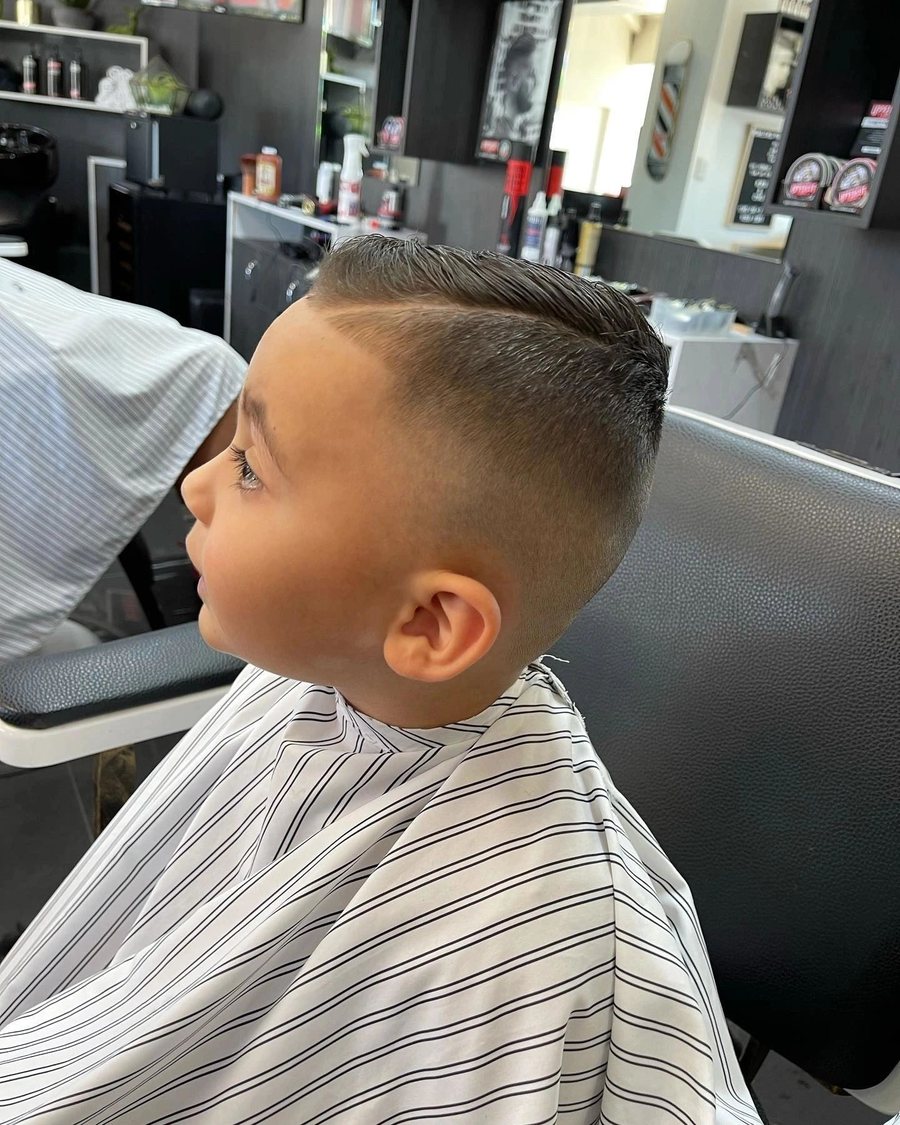 Young boy in the barber chair with a fresh short back and sides.