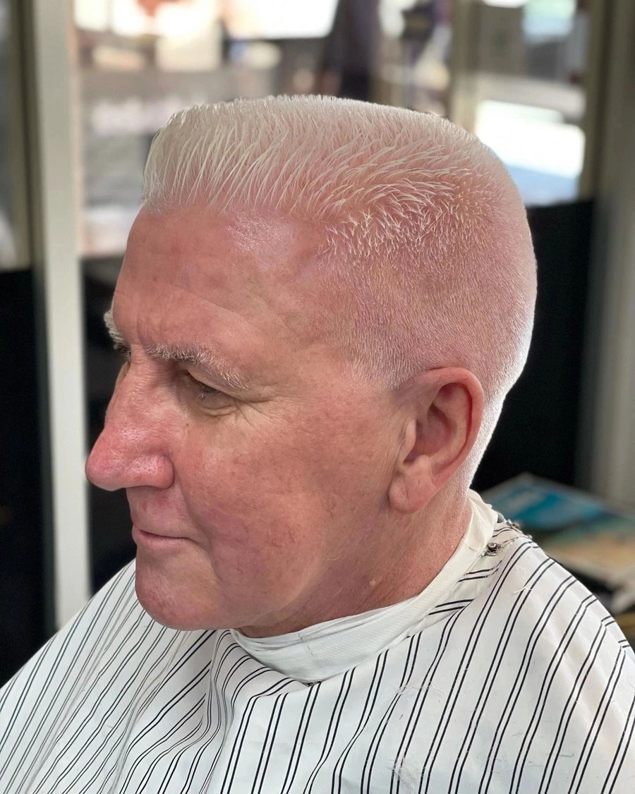 Side profile of an older man with silver hair cut into a short flat top with tapered sides.